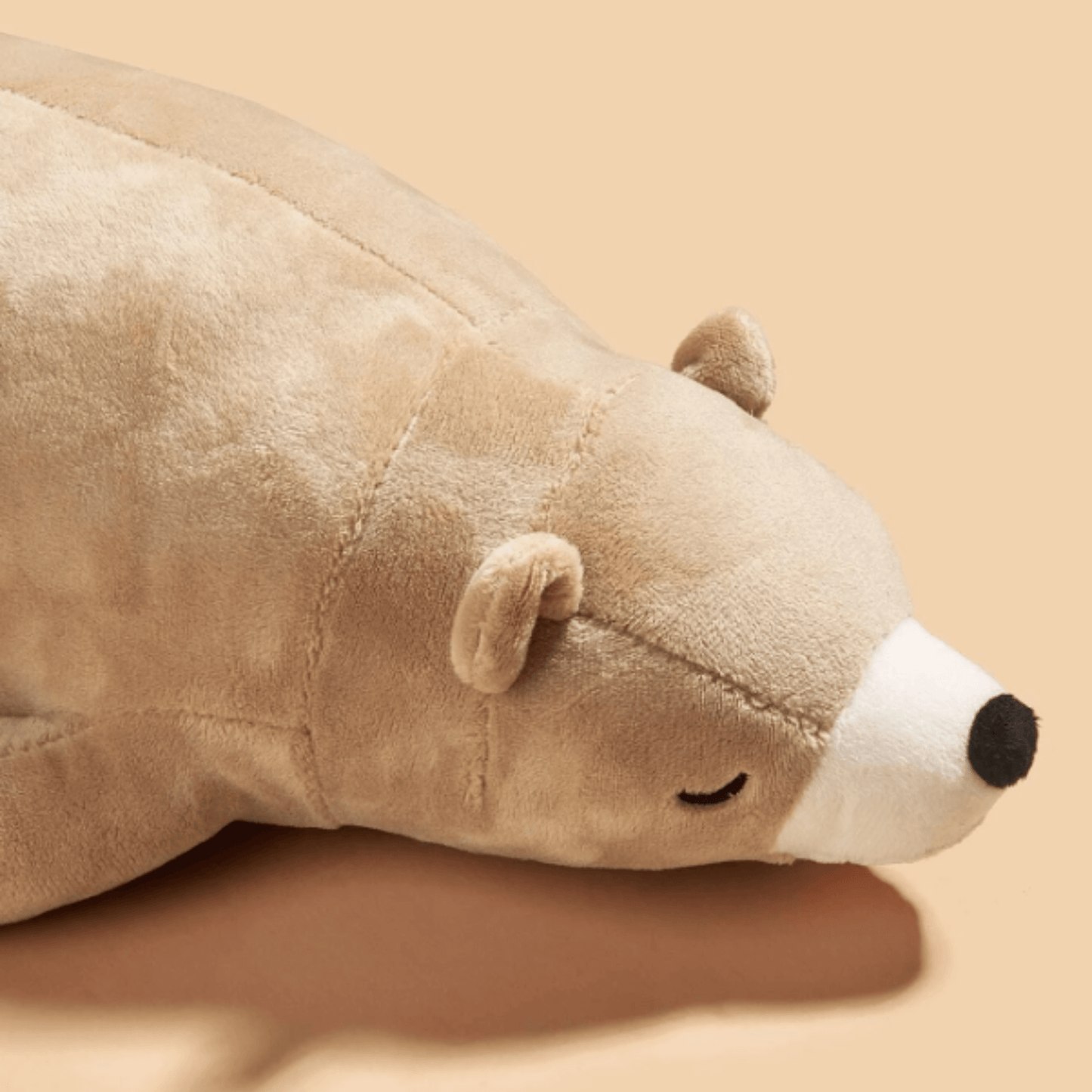 A brown teddy bear dog toy with a squeaker inside. The toy is made of soft plush material and has a long tail. It is perfect for cuddling and provides a sense of security for dogs who are feeling stressed or anxious.
