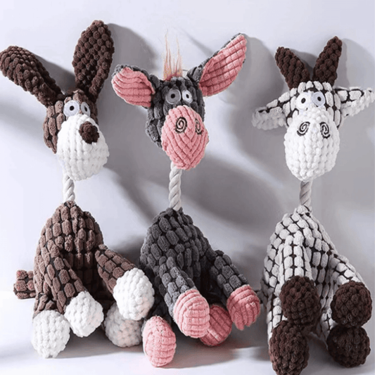 A stuffed giraffe or donkey dog toy with a squeaker inside. The toy is made of soft, plush material and is sitting on a white table. The giraffe or donkey has a long neck and legs, and it is brown or gray in color. The toy has a squeaker inside that will make a noise when your dog chews on it. The toy is perfect for both large and small dogs, and it is sure to keep your furry friend entertained.